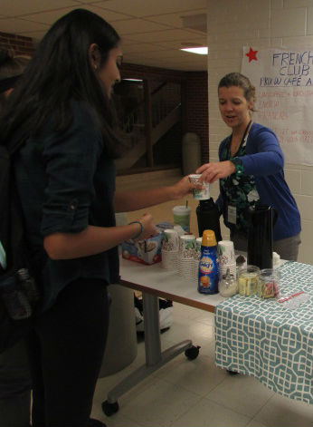 French Club sold coffee, hot chocolate, and croissants to raise money for a future field trip. Adviser Lindsey Evans hands coffee to a student. 