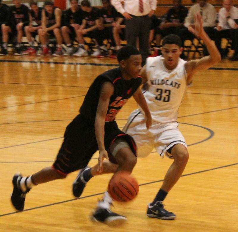 Senior Tai Bibbs blocks the basketball against Glenbard East. The team worked together to win the close game.