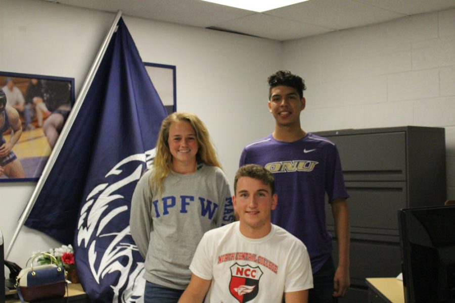 Seniors Emma Gaggioli (left), Sean Sweeney (middle), and Edgar Pani (right) signed to play soccer for their colleges. Parents stood next to the athletes as they signed for their commitment.