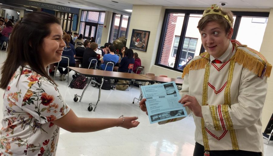 Senior Yessica Gonzalez buys an admission ticket for the Cinderella musical from actor David Brown who dressed up as a prince in support of the themed week.  
