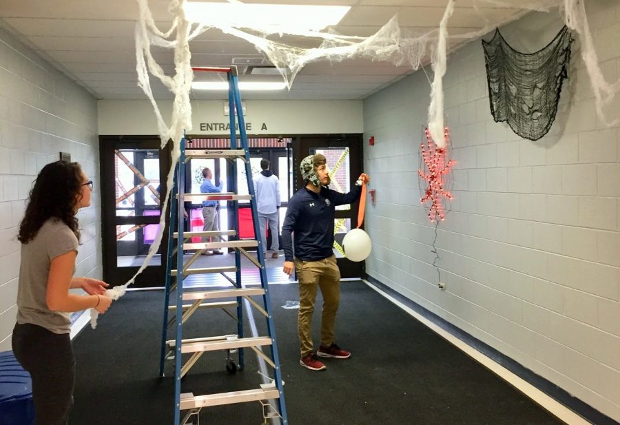  Student Council members, from left, senior Olivia Bartler and Adam Hey meet to decorate entrance A for Spooky Fest Friday. 
