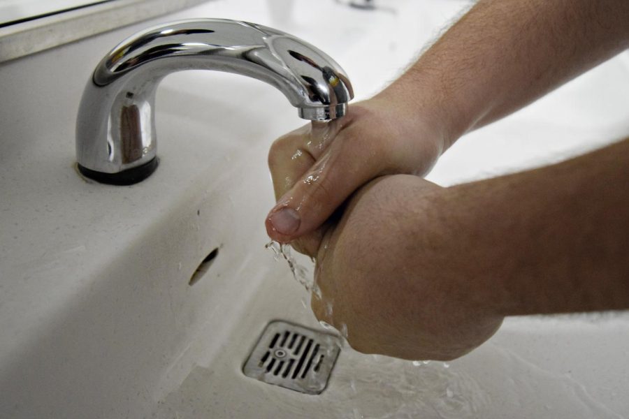 A student washes his hands in a restroom. Many of the reporters on staff have felt pressured to hurry in the restrooms for fear of being scrutinized by the security guards.