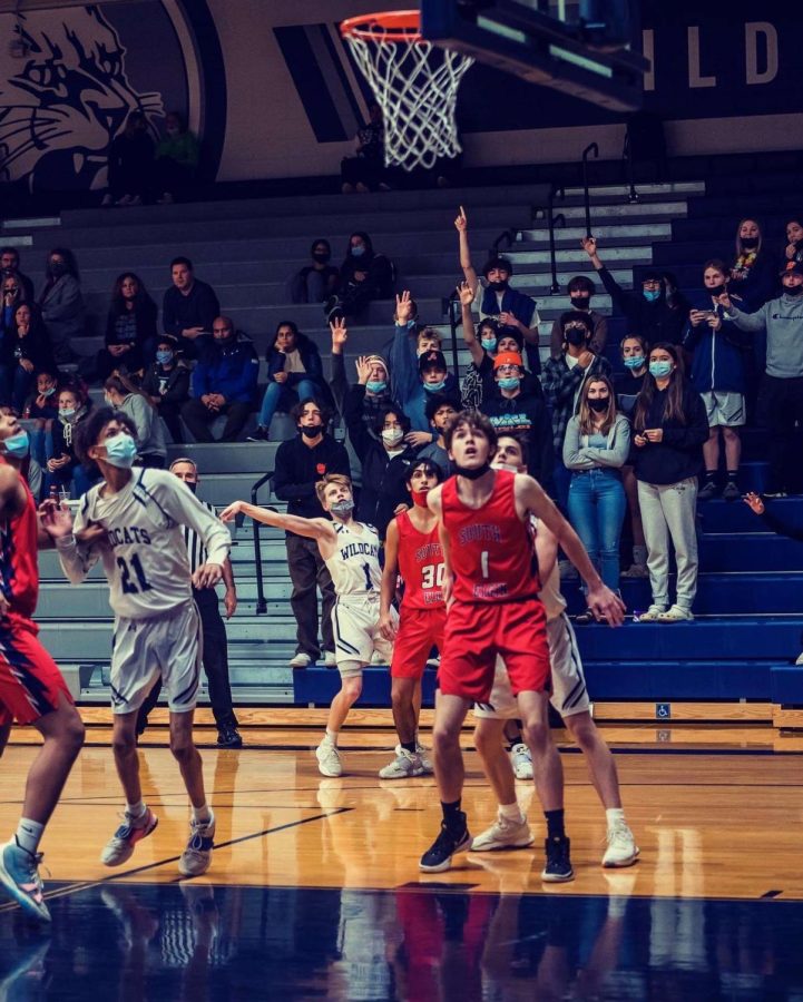 Russo watching his shot attempt in the air while the student section follows.