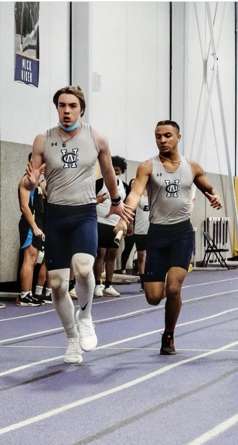 Bates handing off the baton to Wright during the 2022 indoor track season.