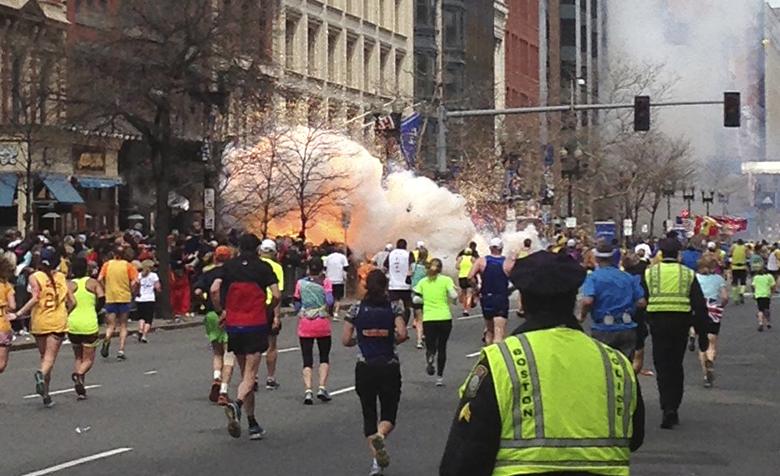 Runners run towards the finish line of the Boston Marathon as an explosion erupts near the finish line of the race in Boston, Massachusetts, April 15, 2013. REUTERS/Dan Lampariello
