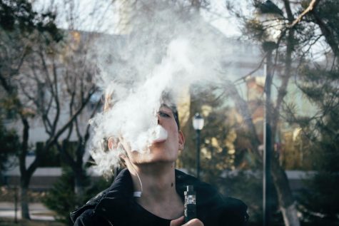 A student is obscured by smoke from a vape pen. (Royalty-free photo courtesy of Ruslan Alekso via Pexels)