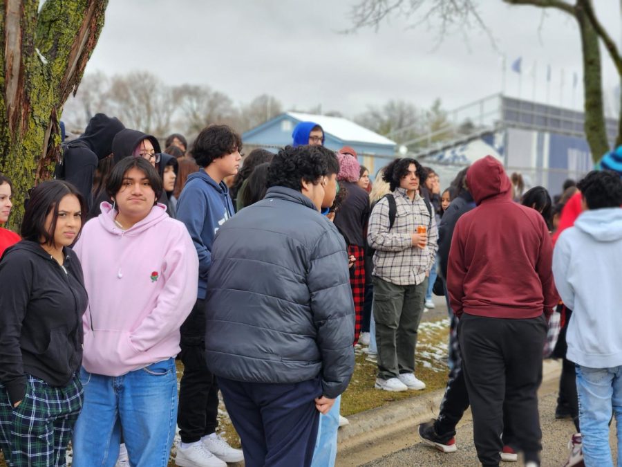 Students stand in front of the stadium fence alongside Wood Street in West Chicago.
