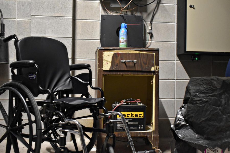 A solitary wheelchair sits near a broken nightstand in the backroom of the third floor.