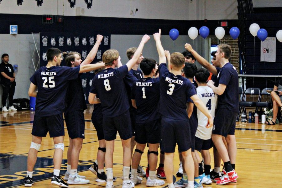 The boys varsity volleyball team hyping each other up before a home game. 
