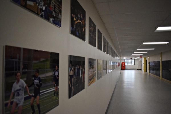 An empty hallway lined with photographs of West Chicago Community High School students.