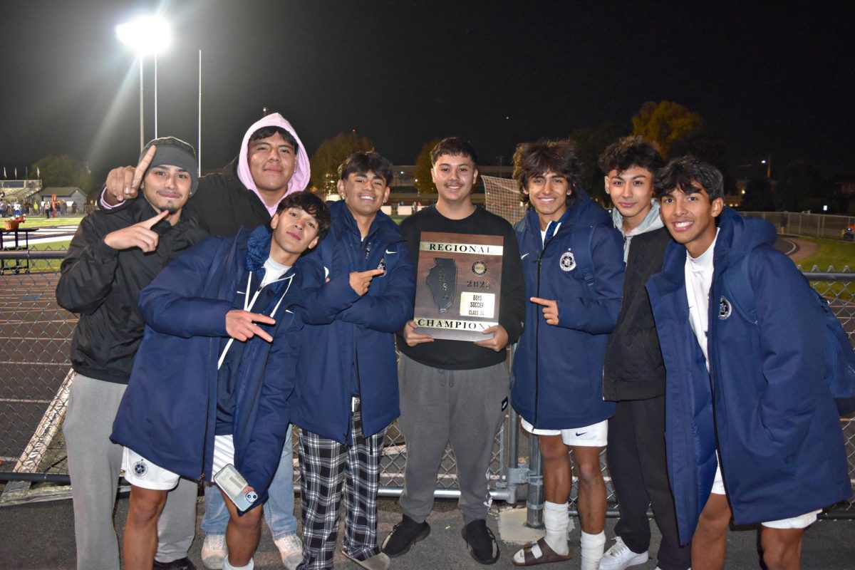 Boys soccer team players hold up the plaque they received from IHSA following their win over St. Charles. The team celebrated their victory at the home football game on Oct. 20.