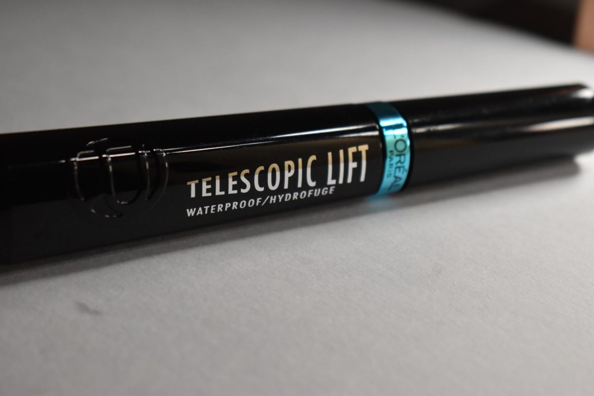 LOreals Telescopic Lift Volumizing Mascara is packaged in a glossy black tube with a chrome blue line and silver letters flashing the product name and brand.
