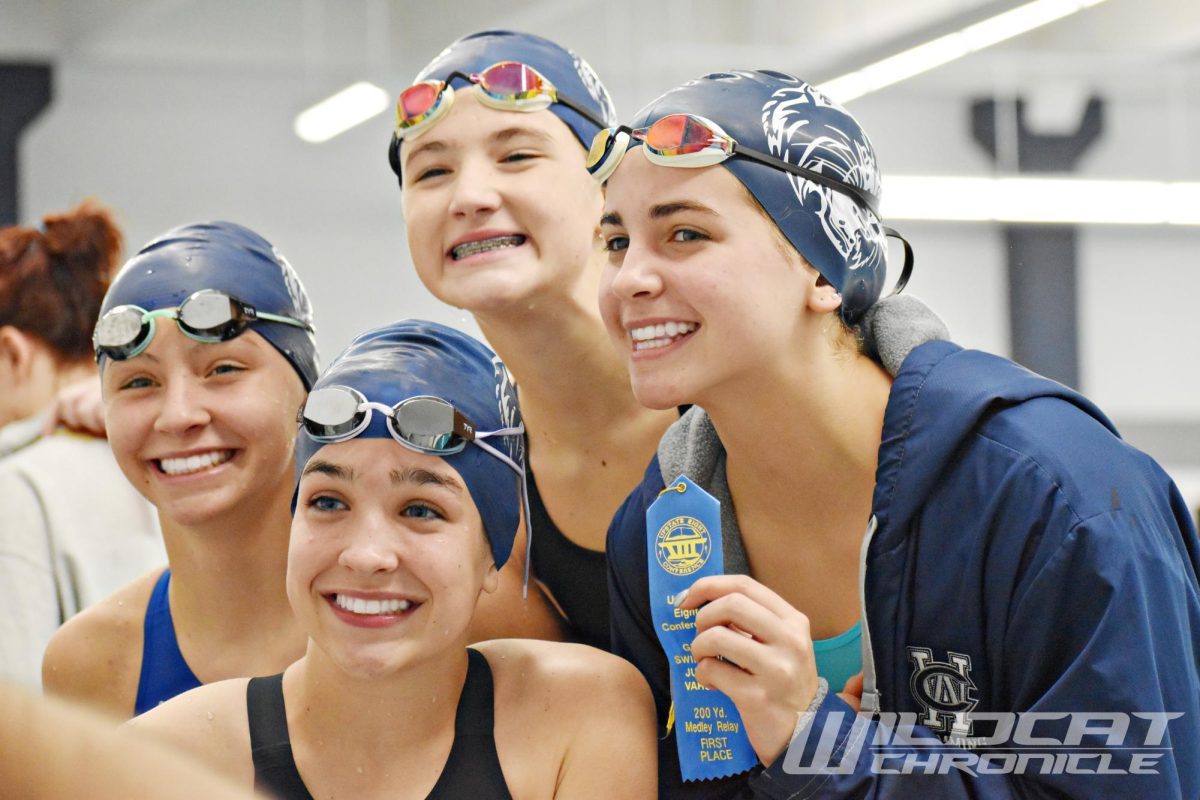 The first place 200-yard medley relay team is congratulated on their win. From left to right: freshman Claire Schumacher, freshman Katherine Smith, freshman Ryan Lehan, and freshman Maddie Seykora.