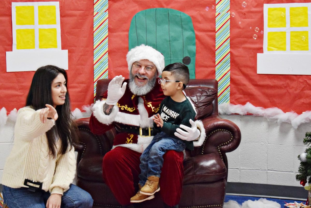 Santa Claus meets with senior Melanie Duran and her baby brother.