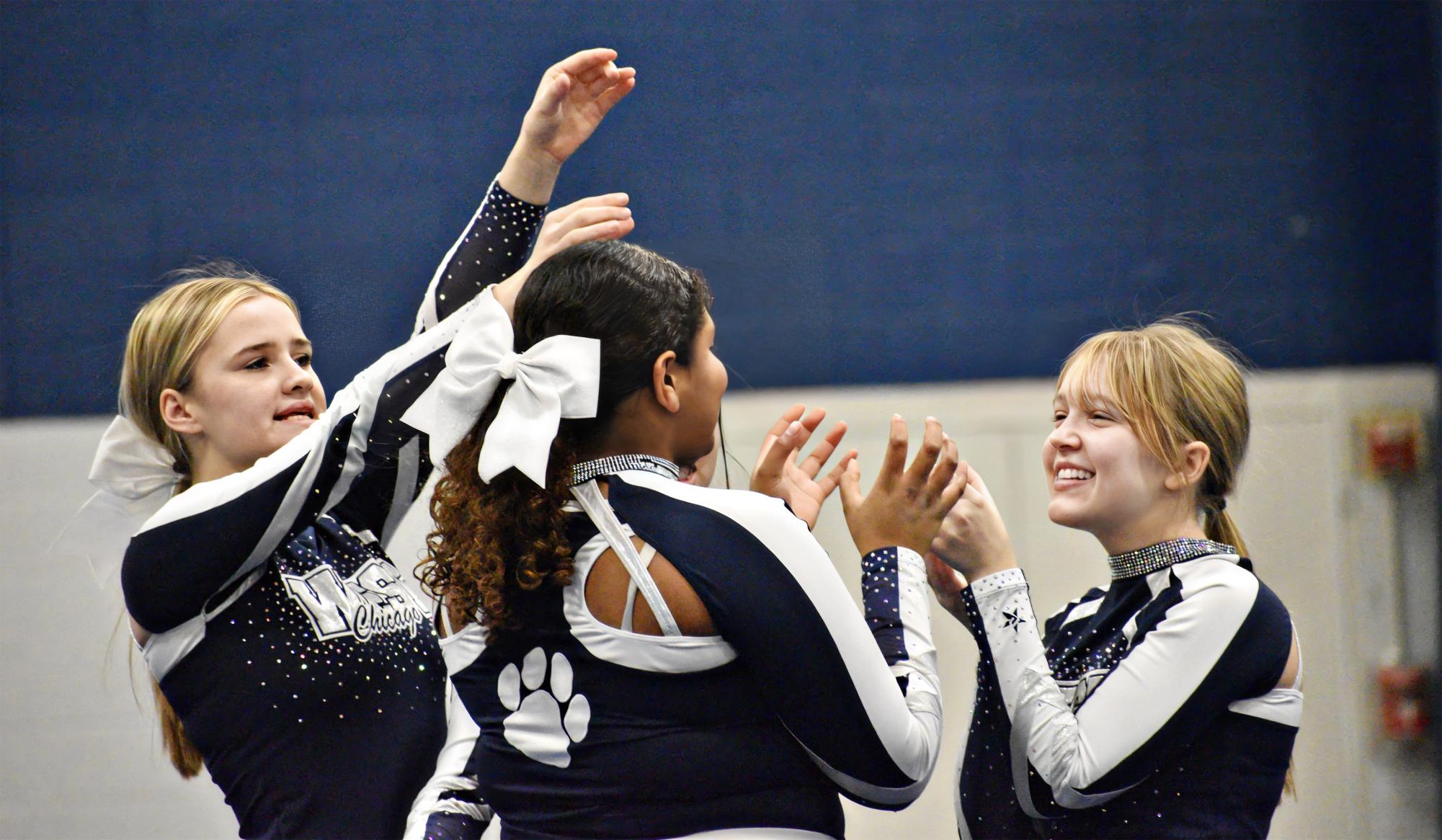 Cheerleaders congratulate each other on a well-done routine.