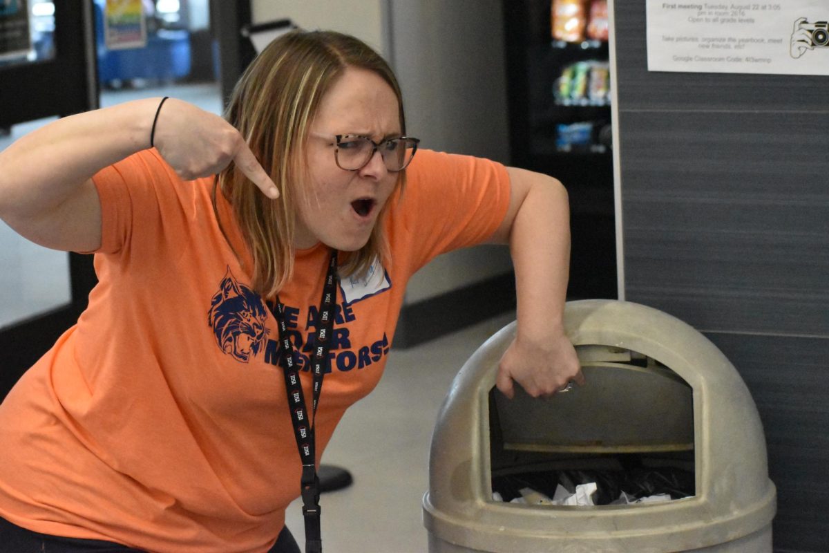 Krysta Schoenbeck points at the garbage, where all the negative paper comments were torn up and thrown away. 