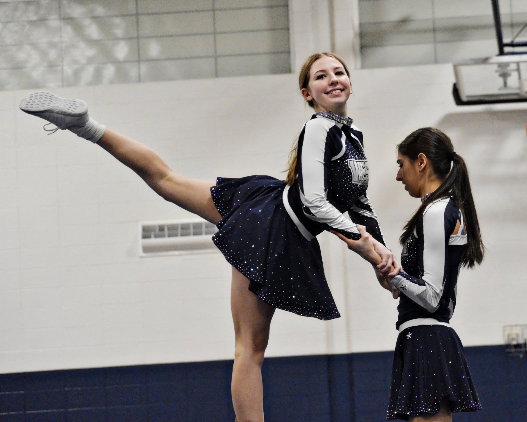 Freshman Tierney Doyle works on her stunts with senior Lucia Rodriguez during practice.