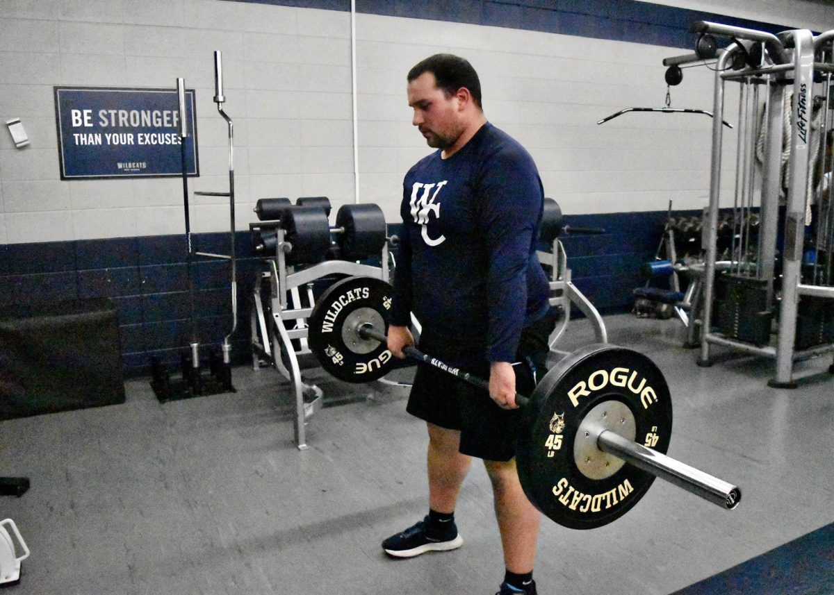 Coach Duszynski completes a romanian deadlift in the weight room. 