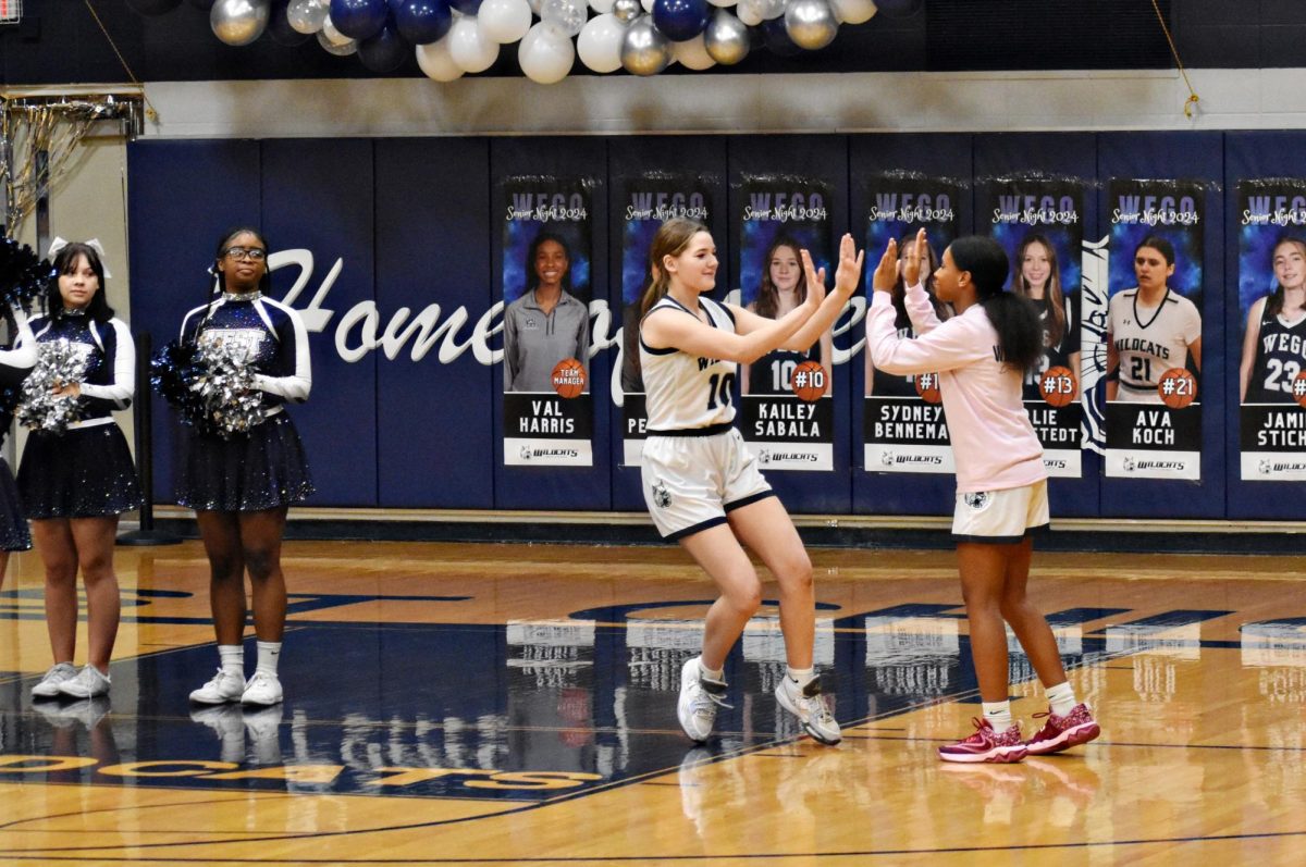All of the senior girls, including Kailey Sabala, were introduced before the start of the game. She high-fives team manager Valerie Harris, also a senior.