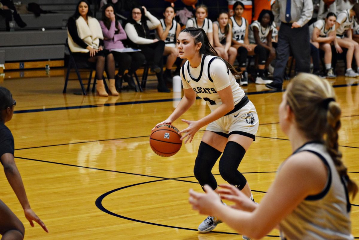 Junior Jasmyn Trigueros, who led in point-scoring during the Feb. 2 game, dribbles the ball down the court while senior Sydney Bennema stays open.