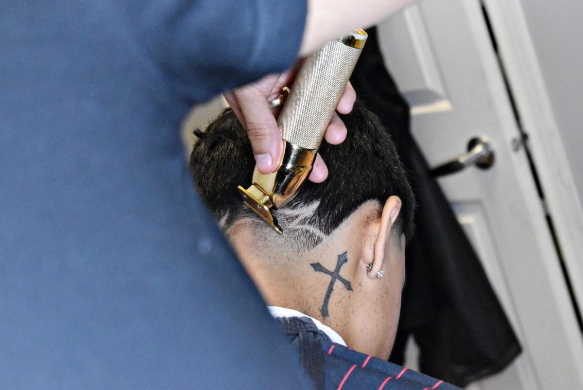 Montoya uses his clippers to create a design his client chooses on the back of his head. This sort of detail work can be difficult.