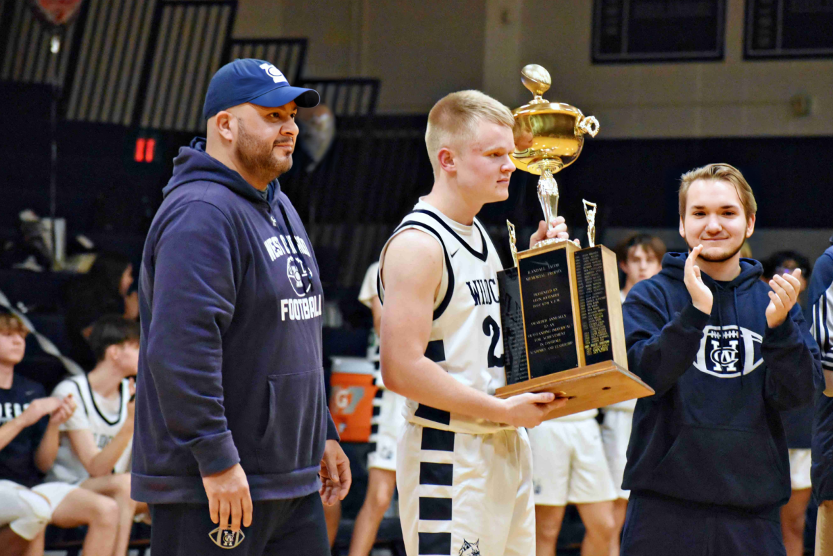 Senior Zach Wiegele is awarded the Randall Jacob Memorial Trophy during the basketball game on Feb. 13. 