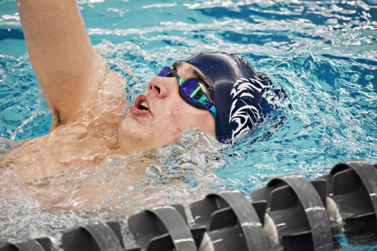 Junior Sam Ortiz swims the backstroke while the pool is open during a break.
