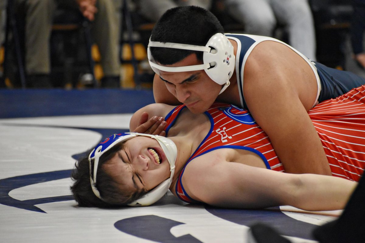 Senior Alan Munoz pins his opponent to the mat late in the match.