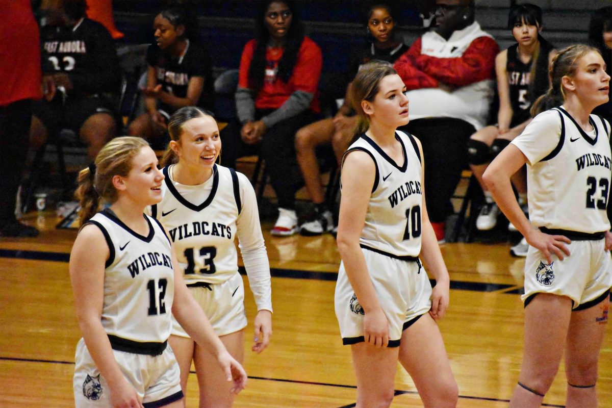 Seniors Sydney Bennema, Ellie Wingstedt, Kailey Sabala and Jamie Sticha smile after a successful play against East Aurora. The Wildcats won 59-44.