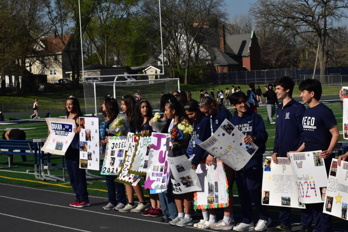 Senior track athletes line up to take a picture together with their posters.