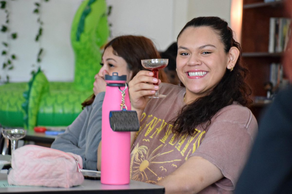 Senior Jayden Huesca Rodriguez raises a glass of sparkling juice to her peers as they participate in a poetry slam in creative writing class. 