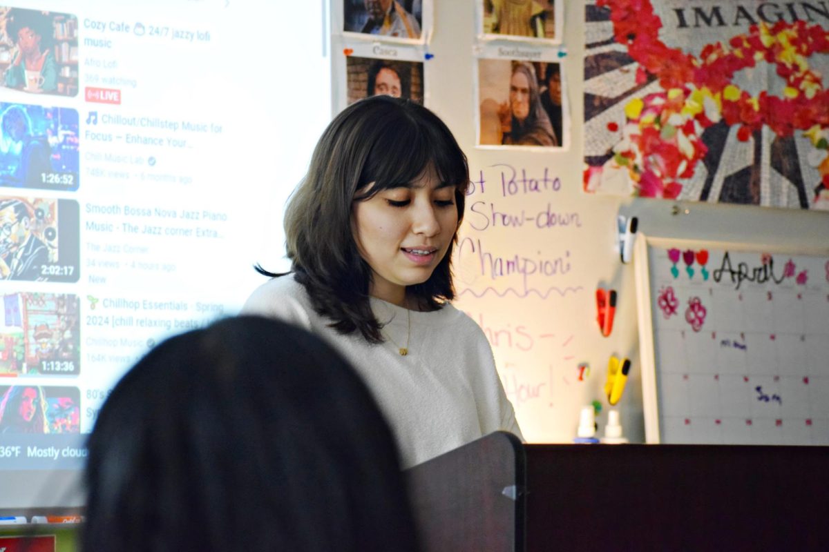 As soft cafe music plays in the background, senior Mariana Acosta presents her poem to the class.