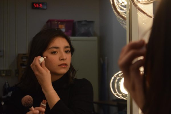 Alex Rocha, a junior in Mean Girls prepares for dress rehearsal by applying her stage makeup. 