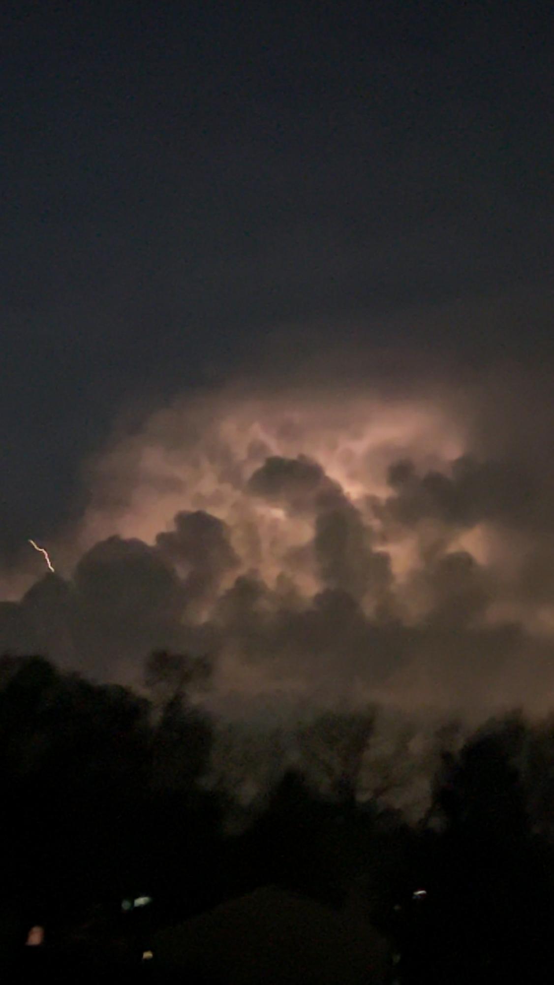 Huge bolts of lightning are striking down while a strong storm is rolling in