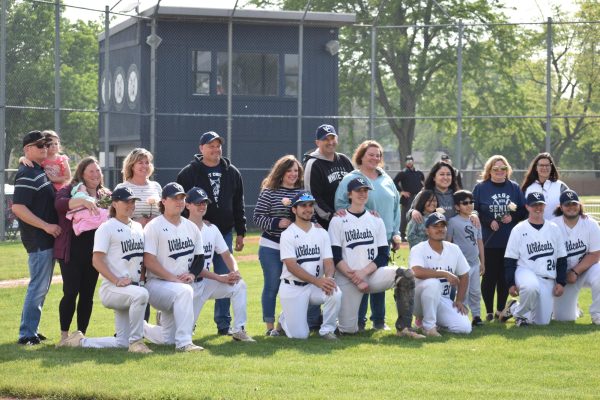 Senior baseball players and their familys line up to take a picture during the pregame ceremony. 