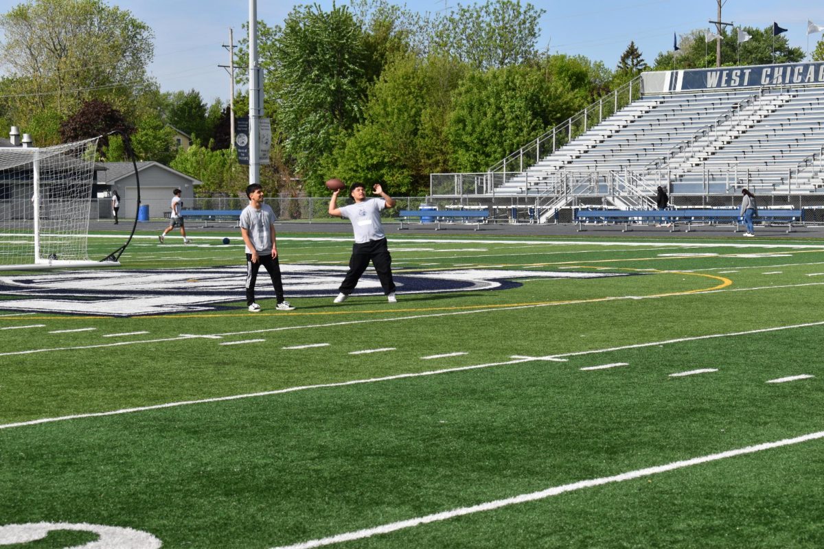 Kids in PE class throw a football around