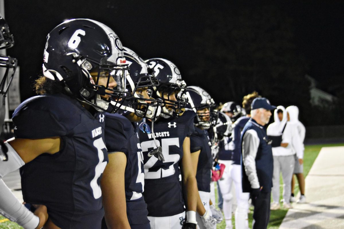 With focus and unity, the Wildcats stand in formation, their numbers fading into the distance as they watch the game unfold.