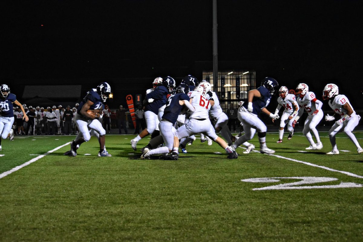 Robert Lee clutches the ball tightly as South Elgin closes in, determined to halt the Wildcats’ advance.