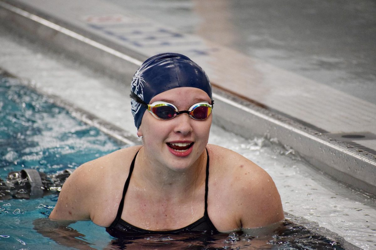 Gabby Clasen, a freshman, laughs at one of her fellow Wildcats as they wait for the next heat to begin.