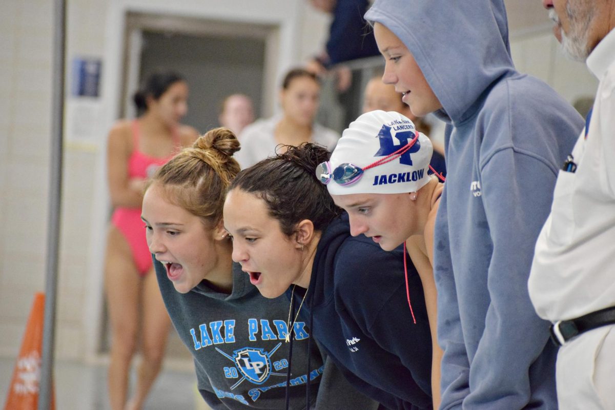 Lake Park swimmers cheer their fellow teammate on as she works her way through the 100-fly.