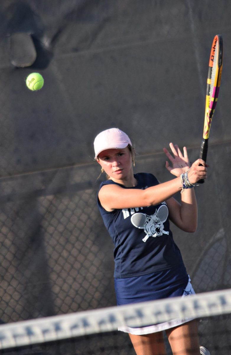 Junior Julia Koput swiftly returns the tennis ball to the opponent's side of the court during the meet against Bartlett on Sept. 16.