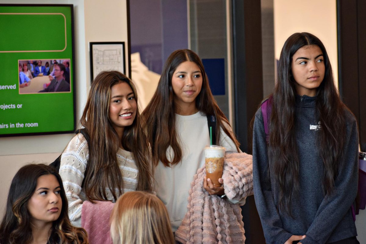 Juniors Valeria Ballines, Alina Ortiz, and Lesley Garcia enter the BYOB event with blankets and coffee while fellow junior Isabella Arreola looks on.