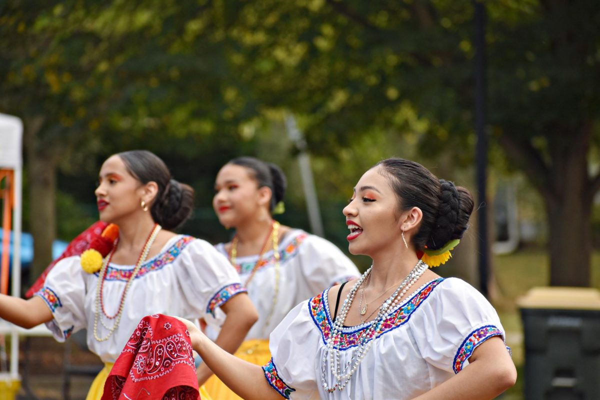 In a playful twist, the female dancers holds the red bandana as they leads the lively choreography, their yellow skirts swirling as they perform the traditional dance from Michoacán, embodying the vibrant energy of Mexican folkloric traditions.