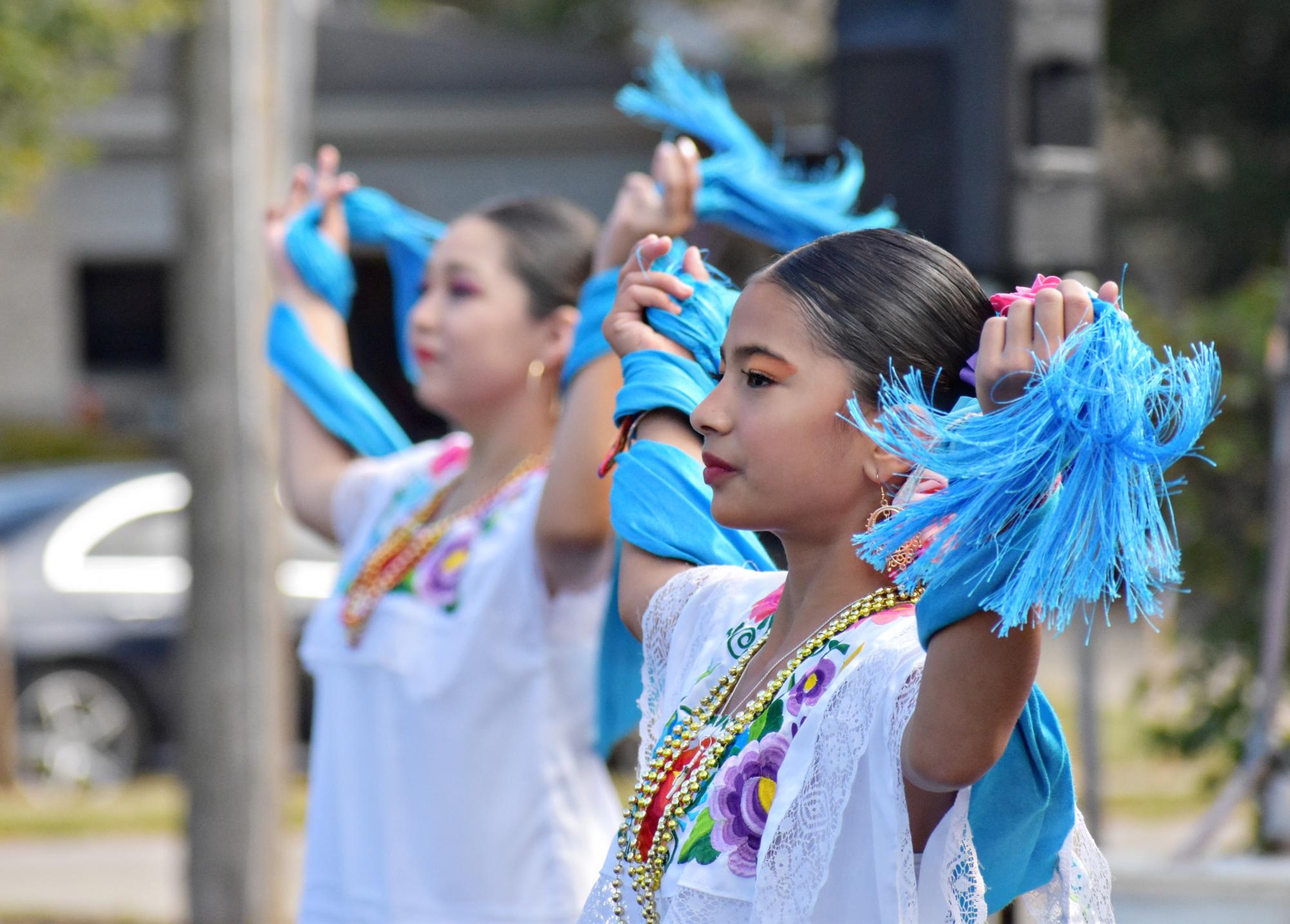 With bright blue scarves in their hands, the dancers perform a traditional dance representing another of Mexico's states.