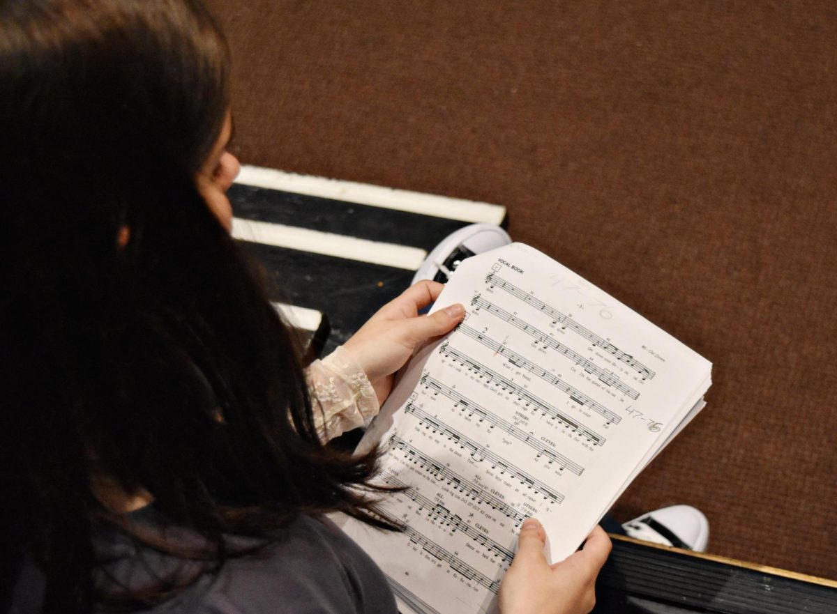 Ava Bloniarz, a junior, looks over the music one last time before auditioning for "SIX" on Sept. 24.