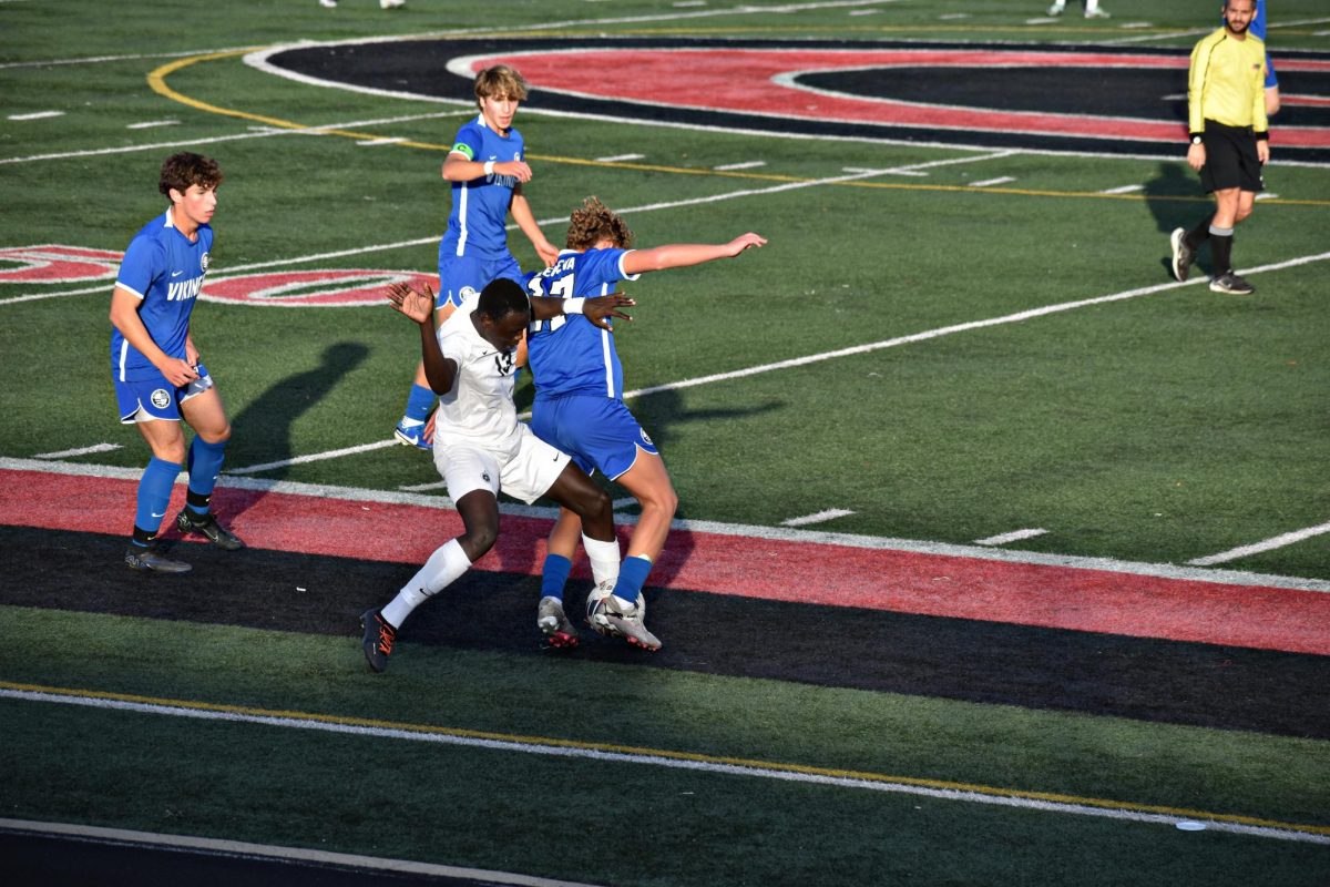 Senior Gafoa Kuku, one of the Wildcats' forwards, strives to intercept the ball from Geneva's players.