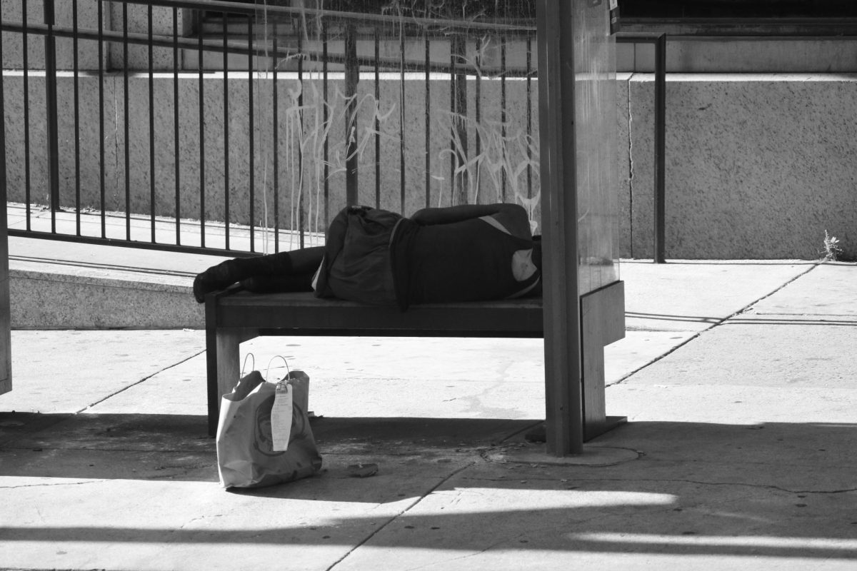 A homeless individual seeking rest and shelter on the streets of Philadelphia.