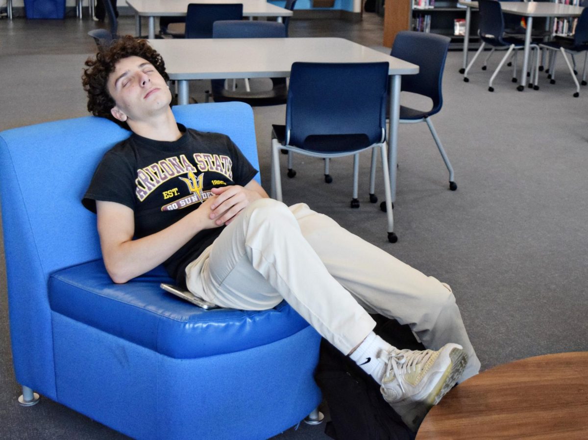 Senior Gavin Dyer pretends to nap in the Learning Resource Center in October 2024.