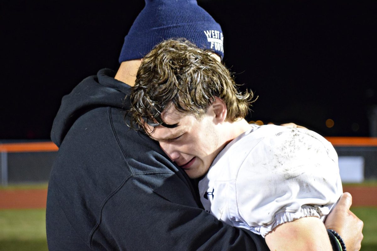 THE AGONY OF DEFEAT: Coach Adam Chavez comforts senior Tommy Murphy after the team's loss to the Ironmen in round one of the playoffs. 