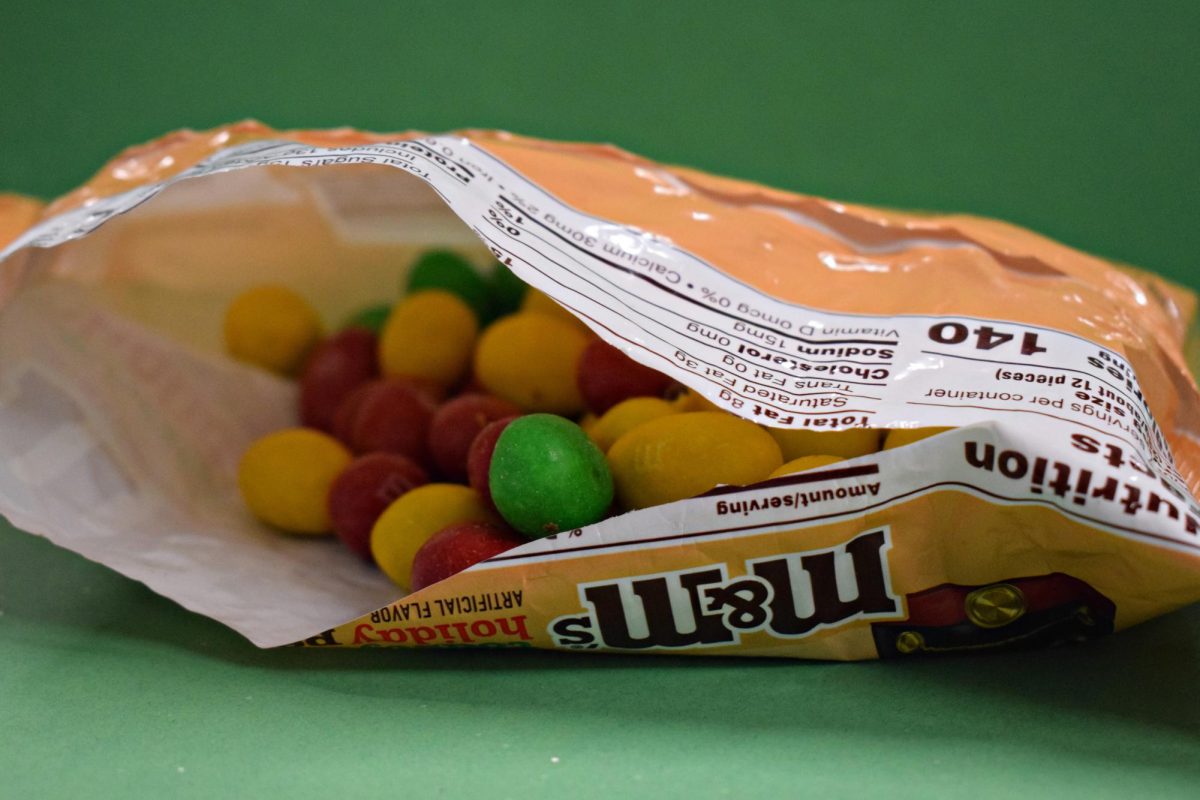 A peek inside the bag of Toasty Holiday Peanut M&Ms, showcasing the red, green, and yellow candies designed for the holiday season.